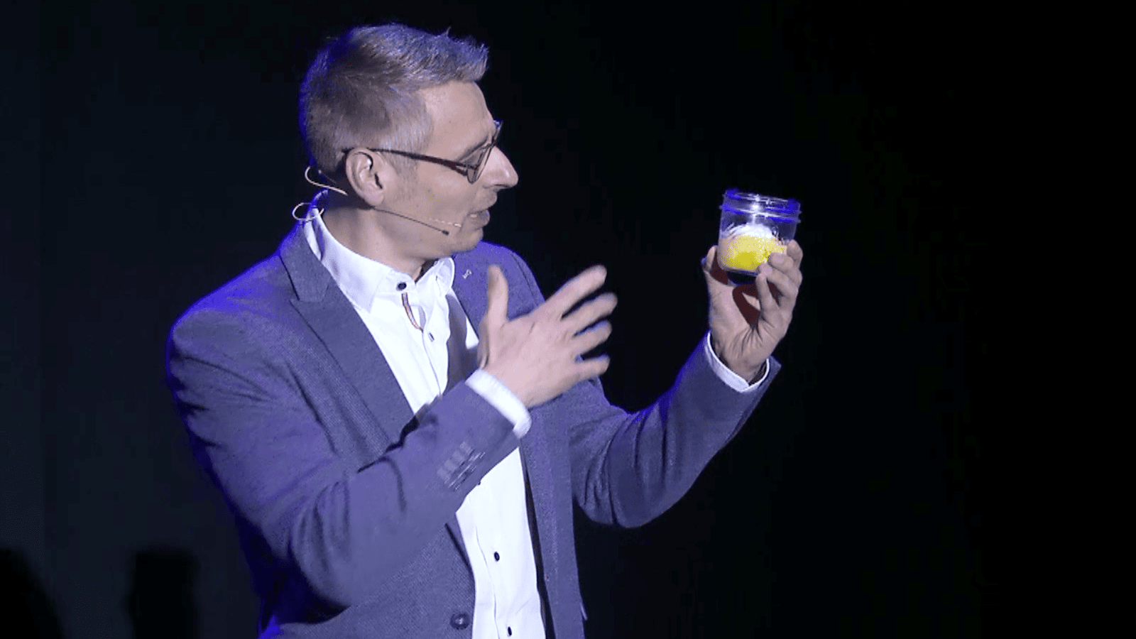 Patrick Schnelle auf der Bühne mit einem Dessert im Glas